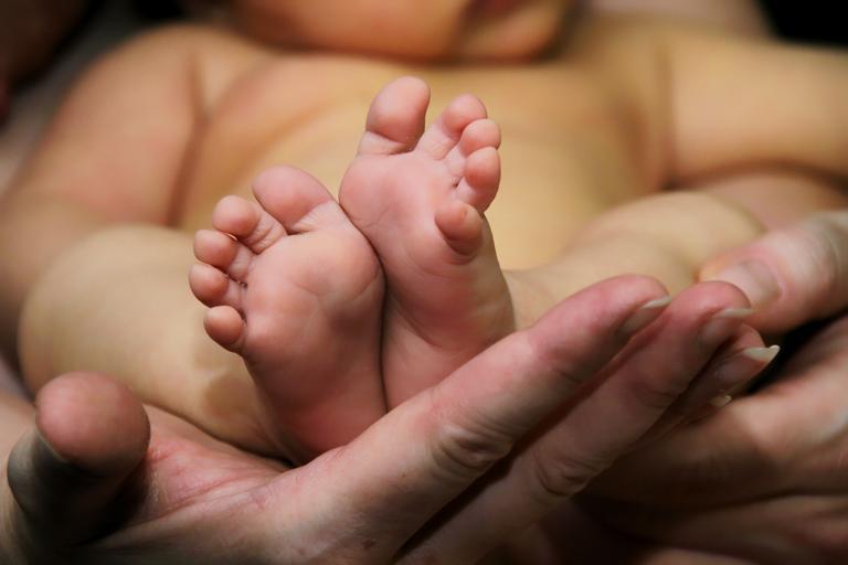 pieds de bébé, main de maman